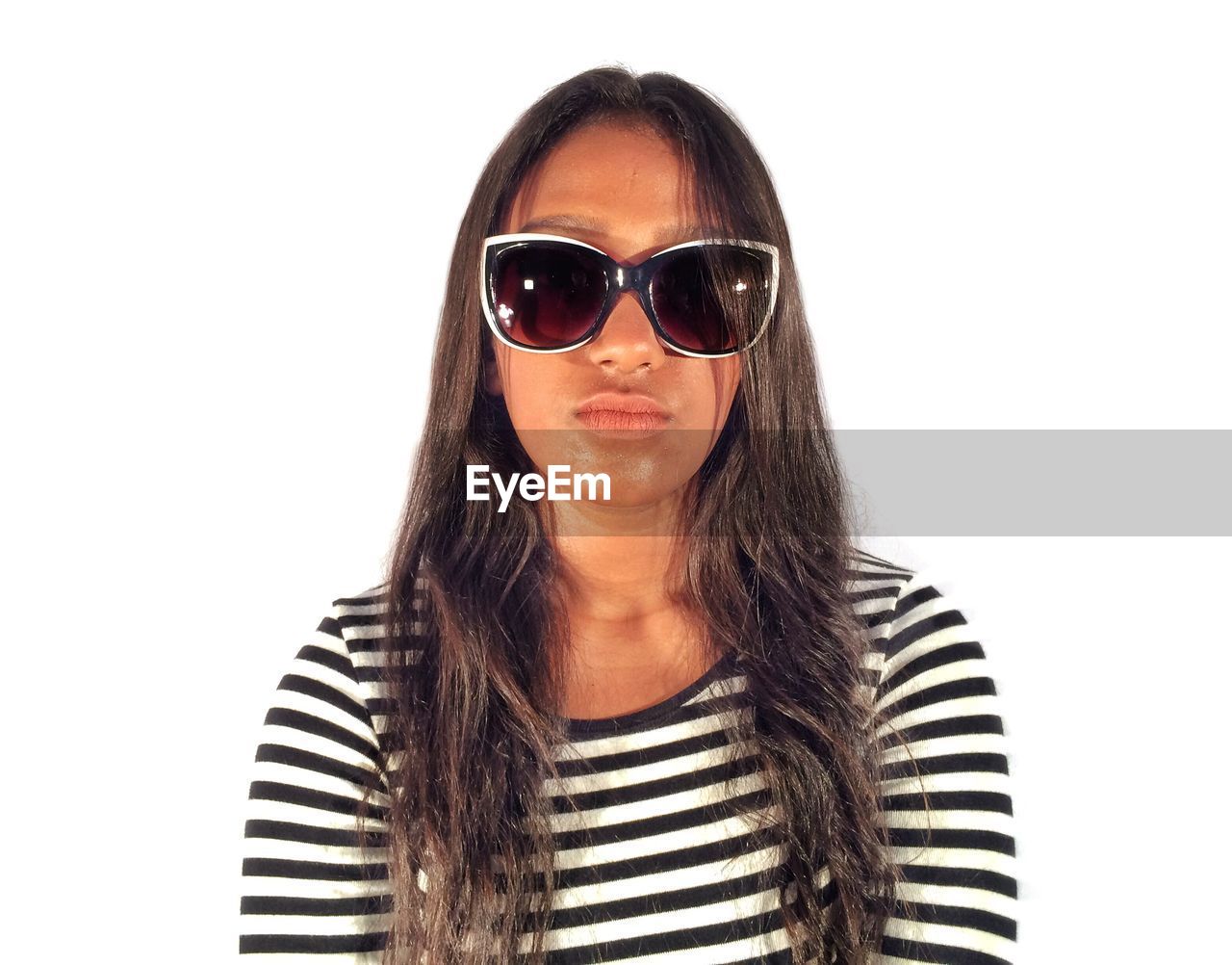 Portrait of woman wearing sunglasses against white background