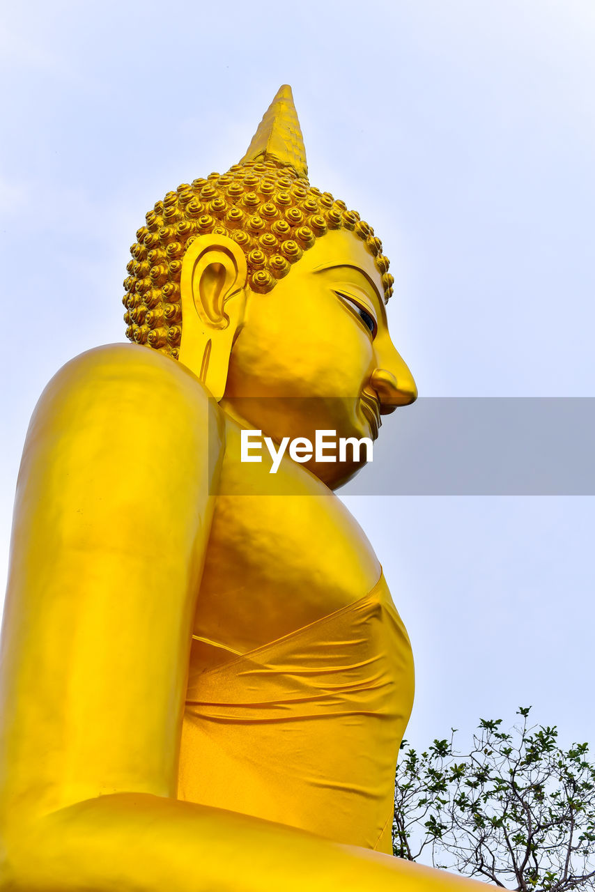 LOW ANGLE VIEW OF STATUE AGAINST YELLOW SKY