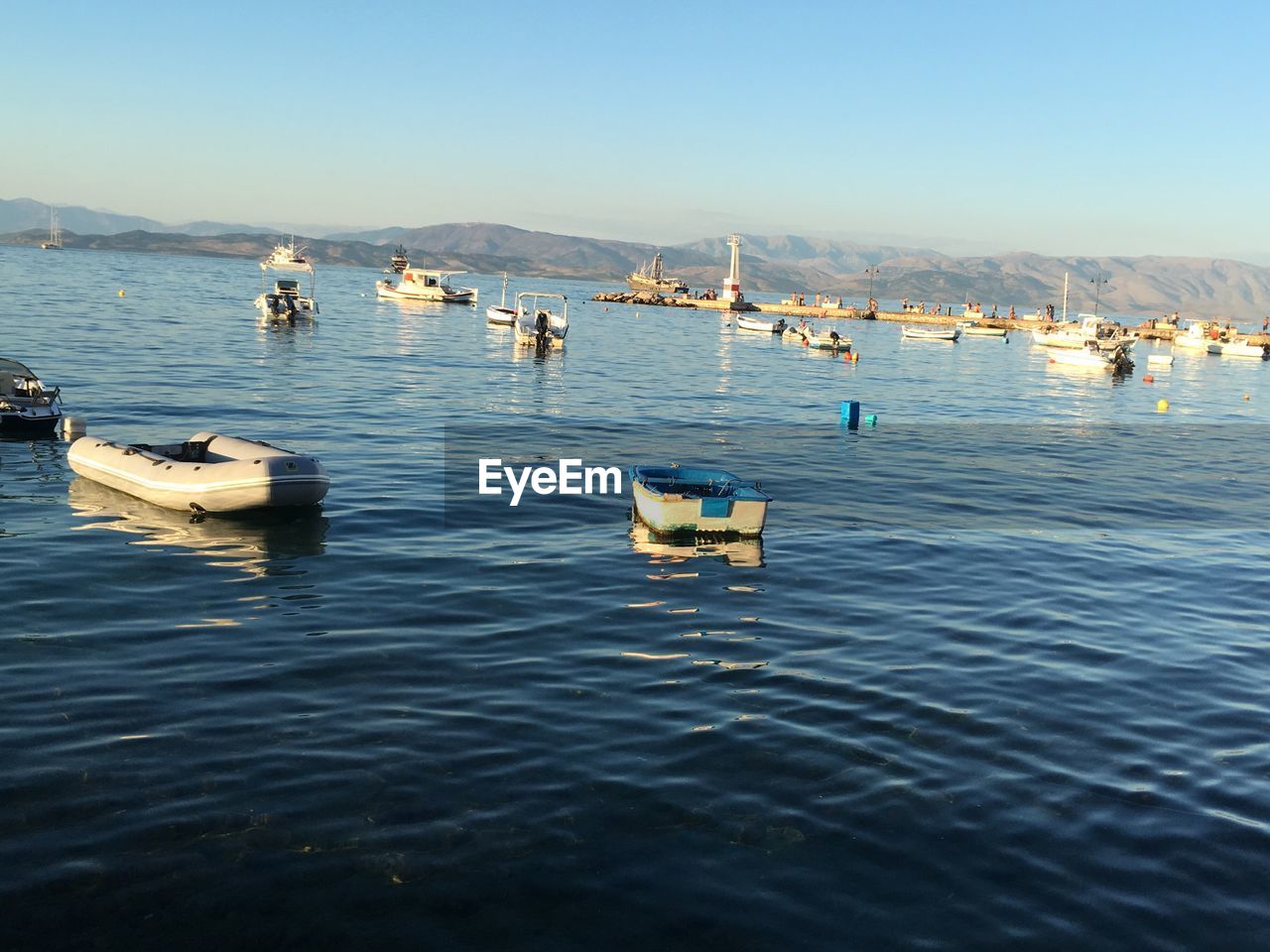 BOATS IN LAKE AGAINST CLEAR SKY