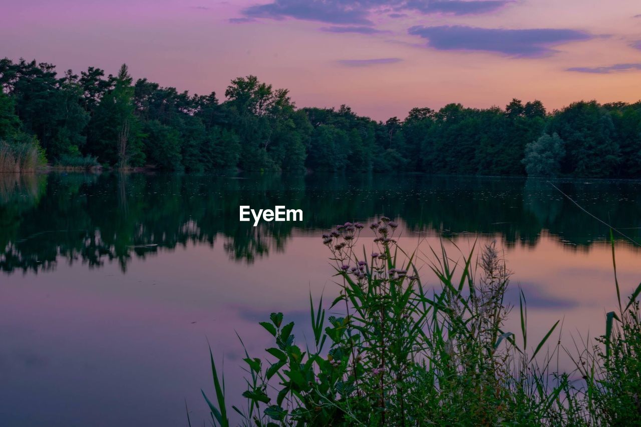 Scenic view of lake against sky at sunset