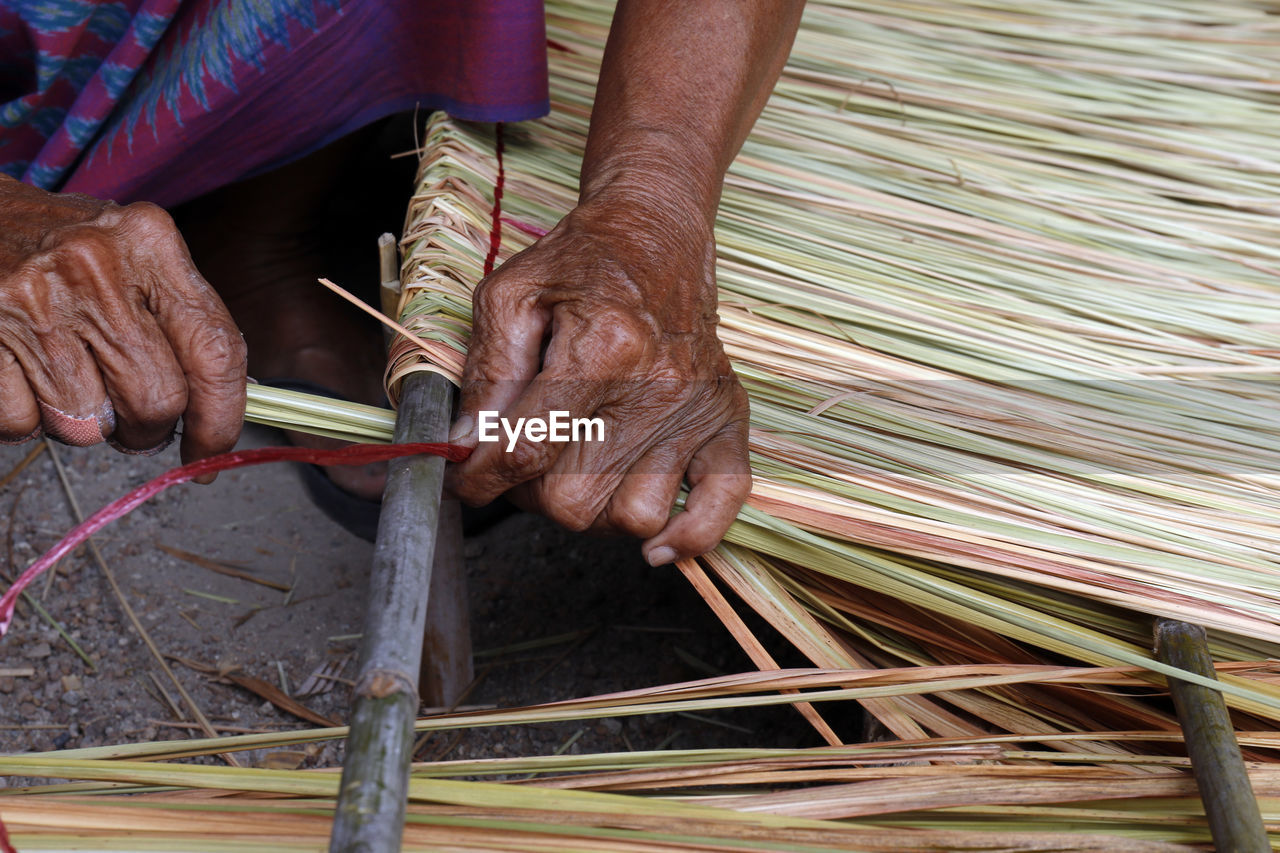 Man weaving straw at workshop