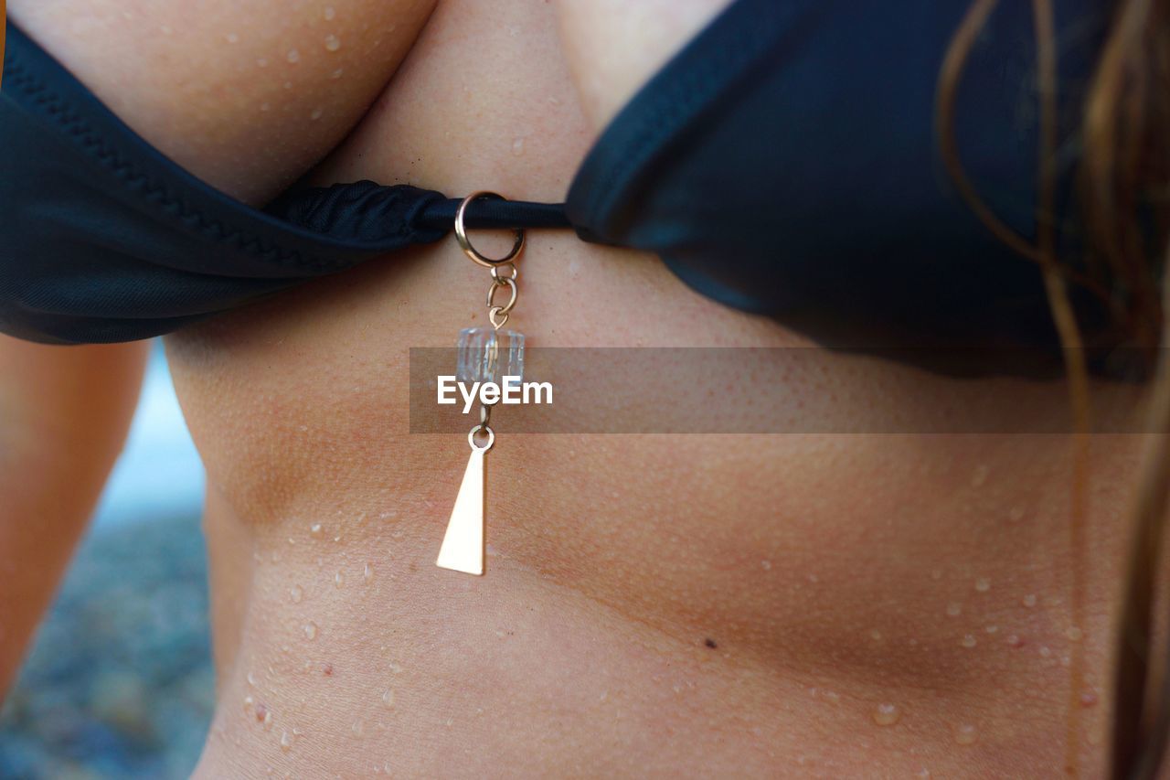 Midsection of sensuous woman wearing bikini top