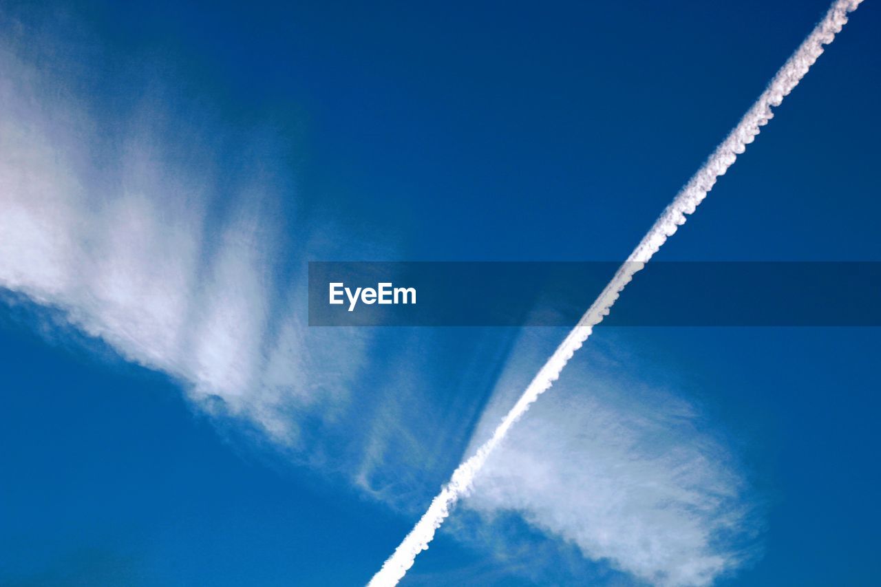 LOW ANGLE VIEW OF AIRPLANE FLYING AGAINST BLUE SKY