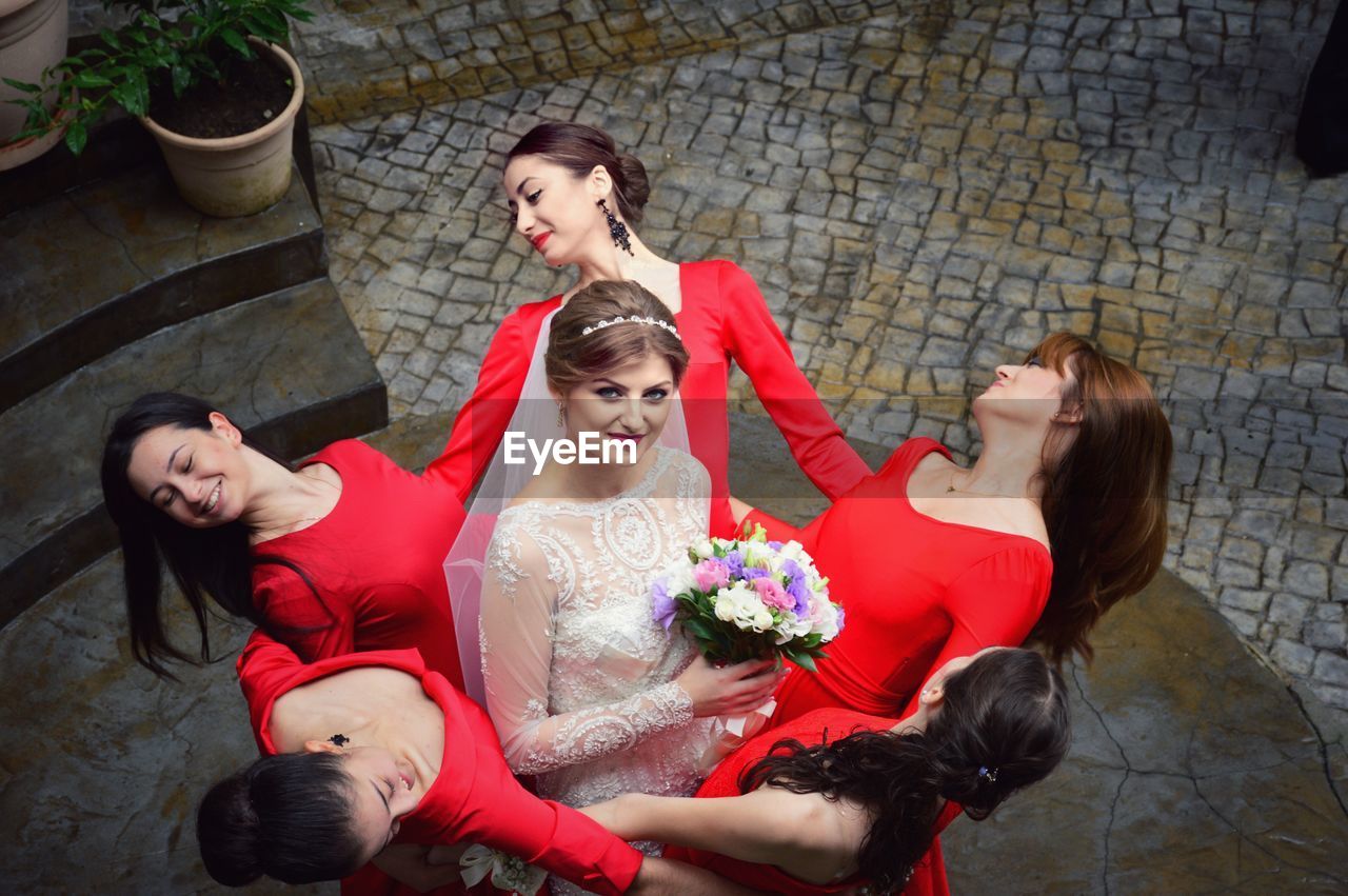 High angle portrait of bride standing amidst bridesmaids