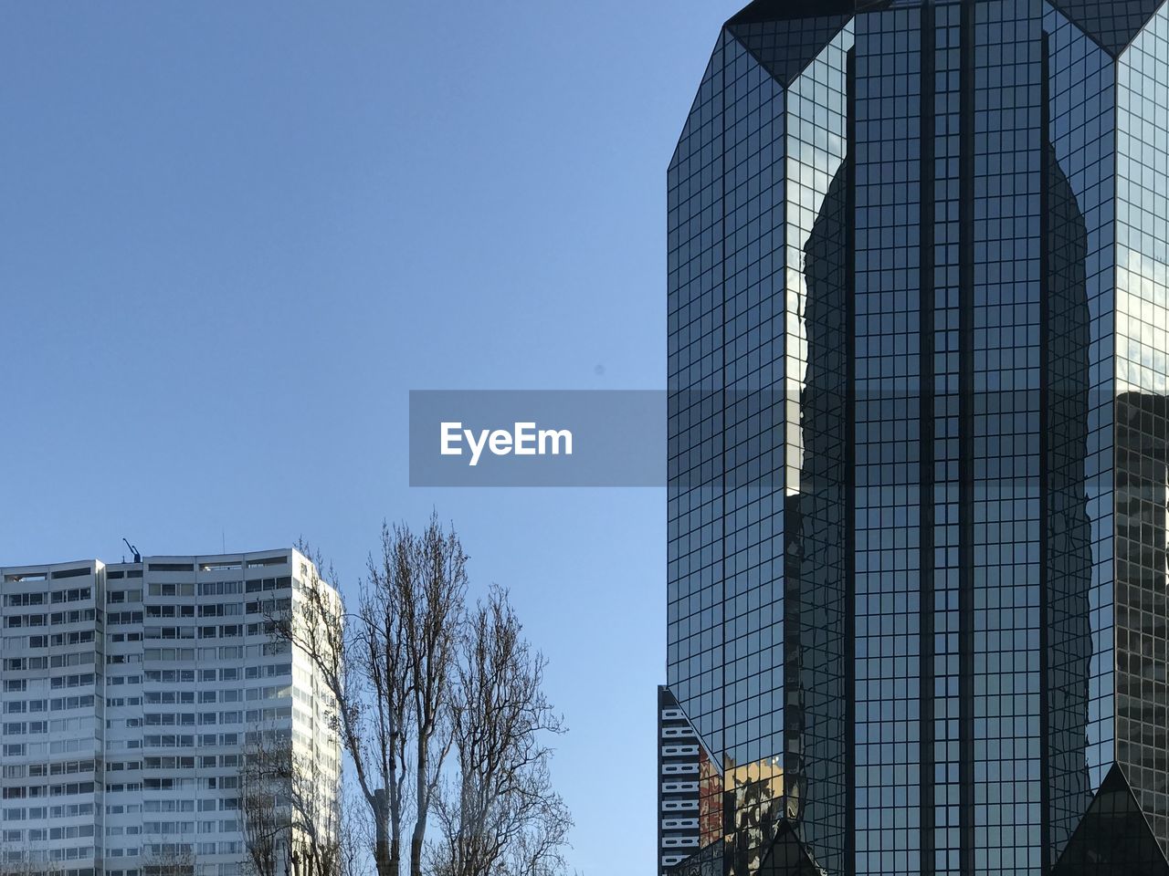 Low angle view of modern building against clear blue sky