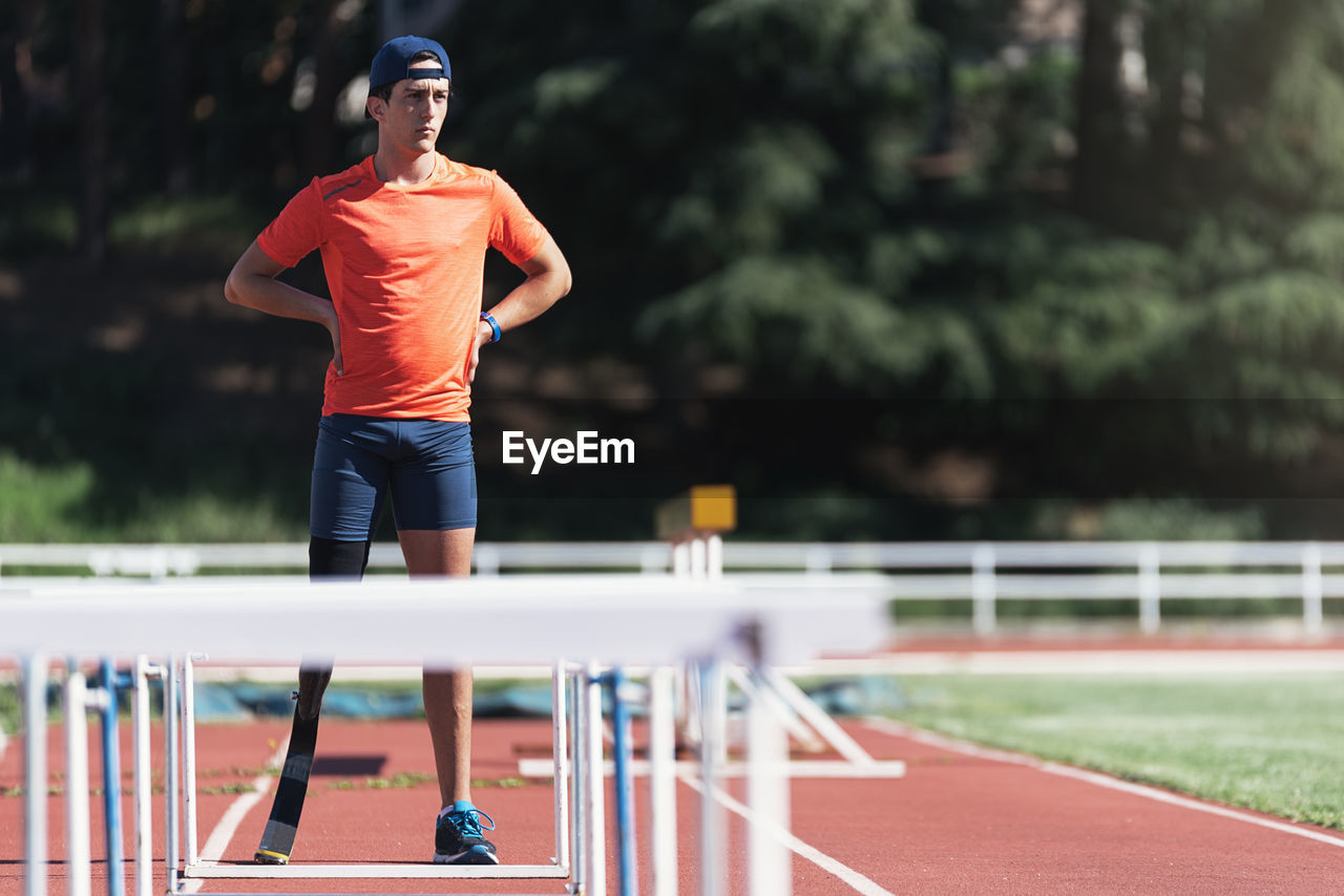 Man with artificial leg standing on running track
