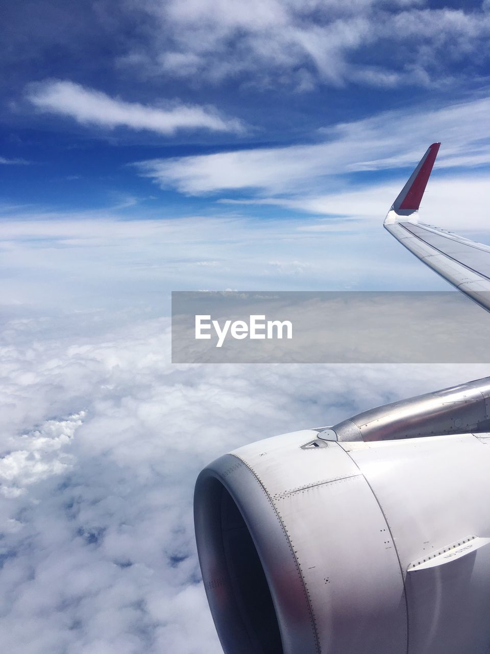 Aerial view of airplane wing over clouds