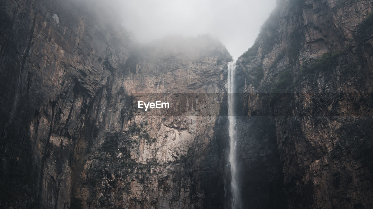 Low angle view of waterfall on mountain