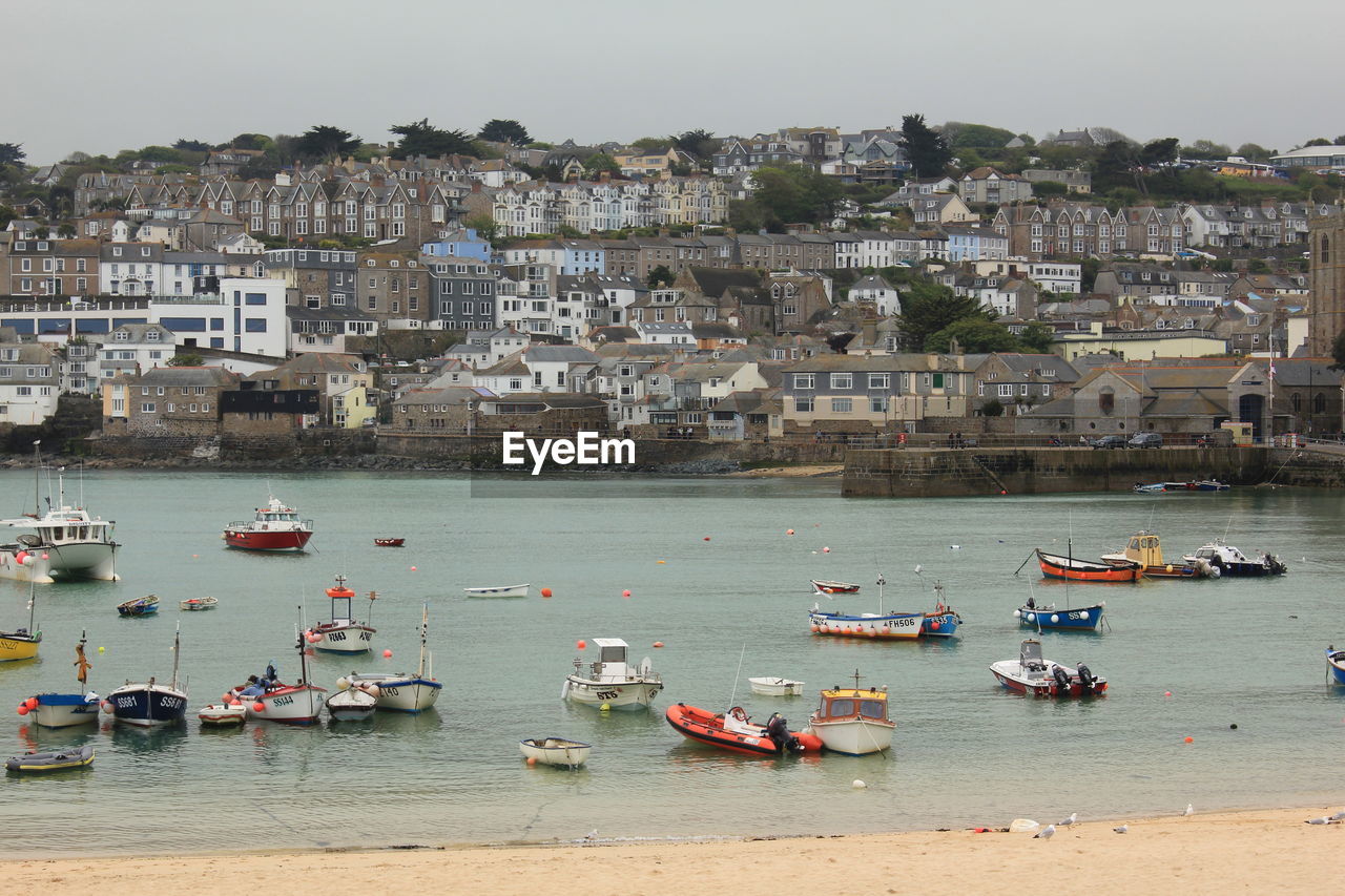 BOATS IN SEA AGAINST CITYSCAPE