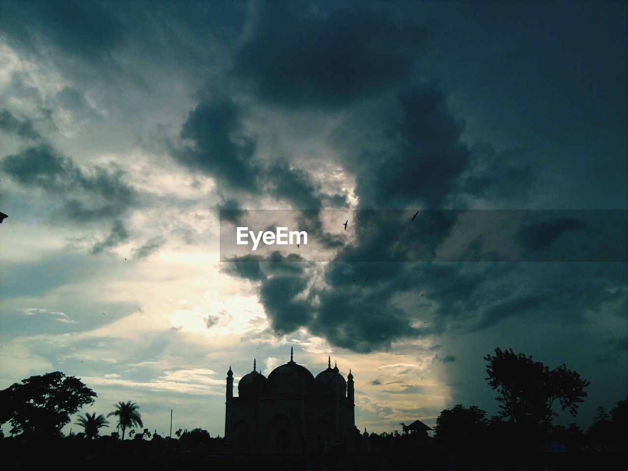 Mosque against cloudy sky during dusk