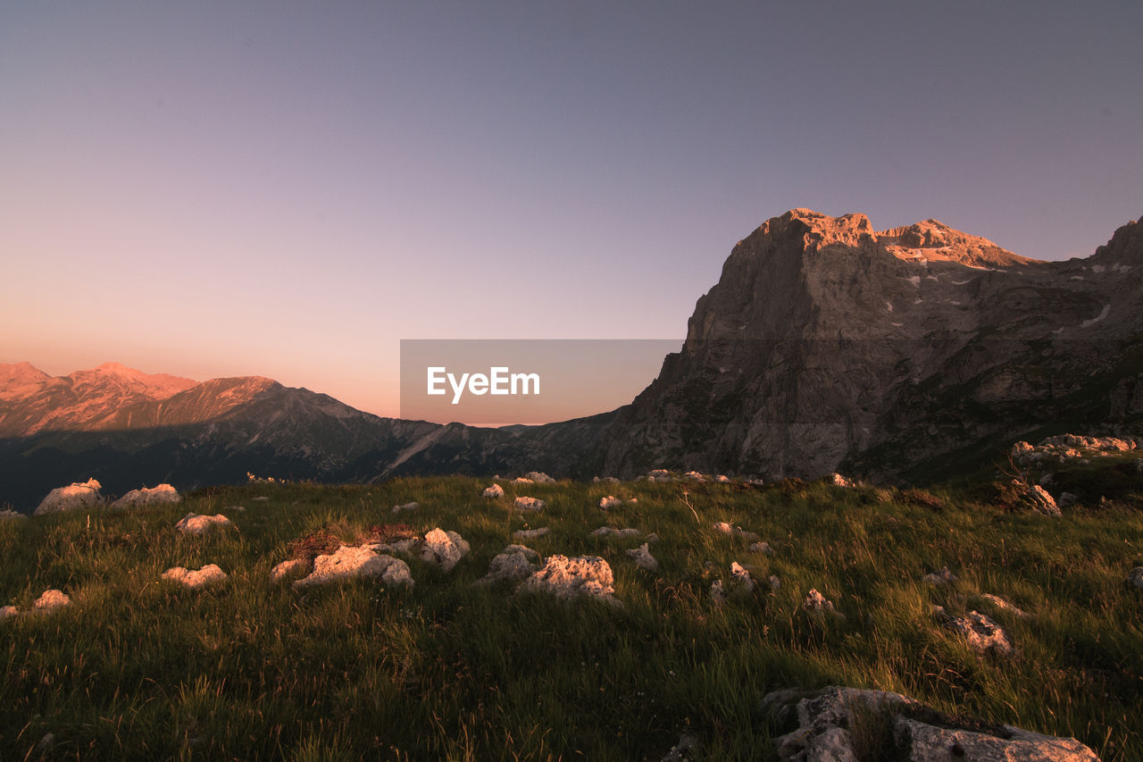 SCENIC VIEW OF MOUNTAINS AGAINST CLEAR SKY DURING SUNSET