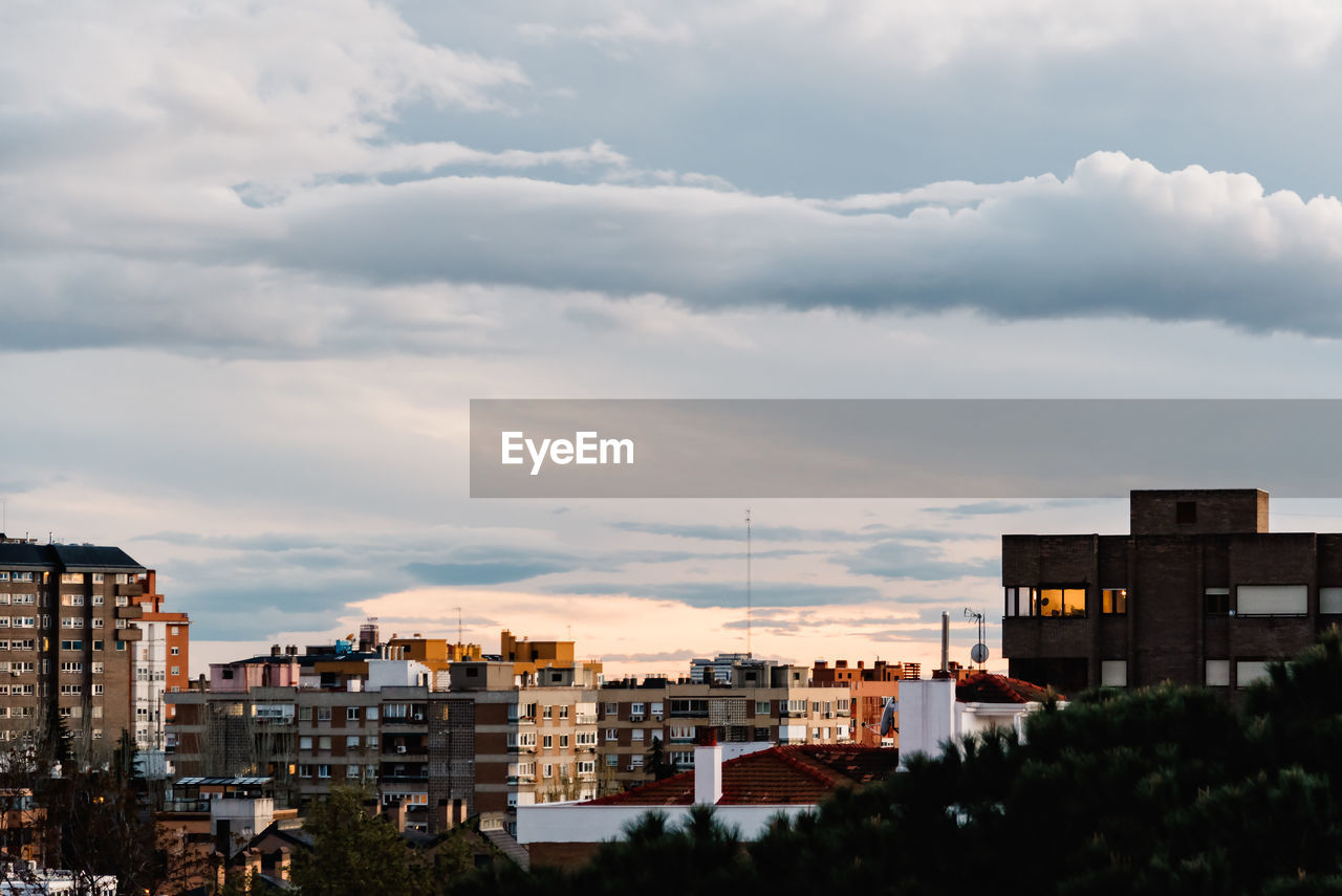 Buildings in city against cloudy sky