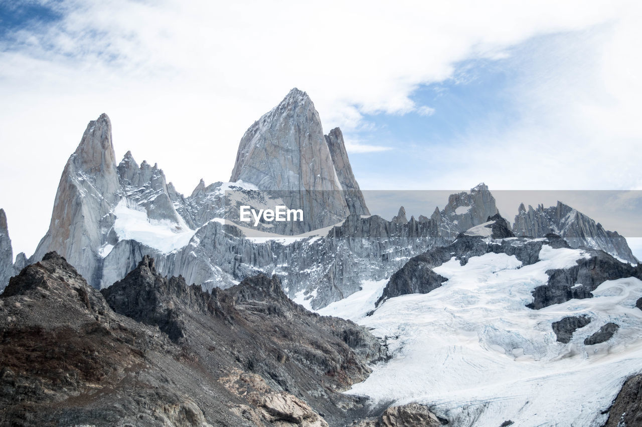 Scenic view of snowcapped mountains and glacier against cloudy sky