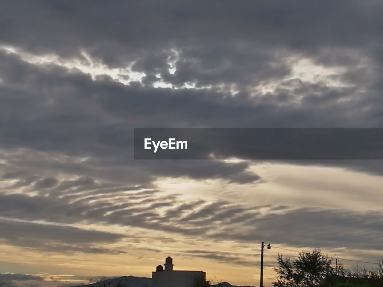 LOW ANGLE VIEW OF BUILDINGS AGAINST DRAMATIC SKY