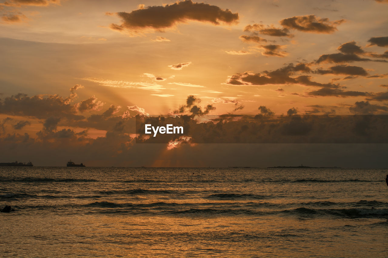 sky, sea, water, sunset, beauty in nature, cloud, scenics - nature, land, nature, environment, tranquility, beach, ocean, horizon, seascape, horizon over water, shore, travel, sun, coast, travel destinations, dramatic sky, holiday, sunlight, tranquil scene, vacation, landscape, trip, idyllic, wave, tropical climate, afterglow, orange color, dawn, no people, outdoors, body of water, evening, motion, tourism, wind wave, reflection, atmospheric mood, summer, gold, cloudscape, multi colored