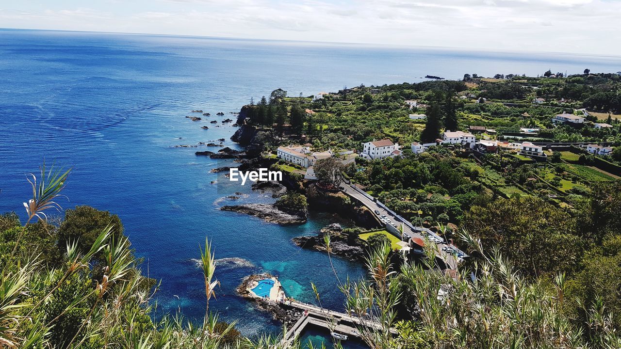 High angle view of townscape by sea against sky