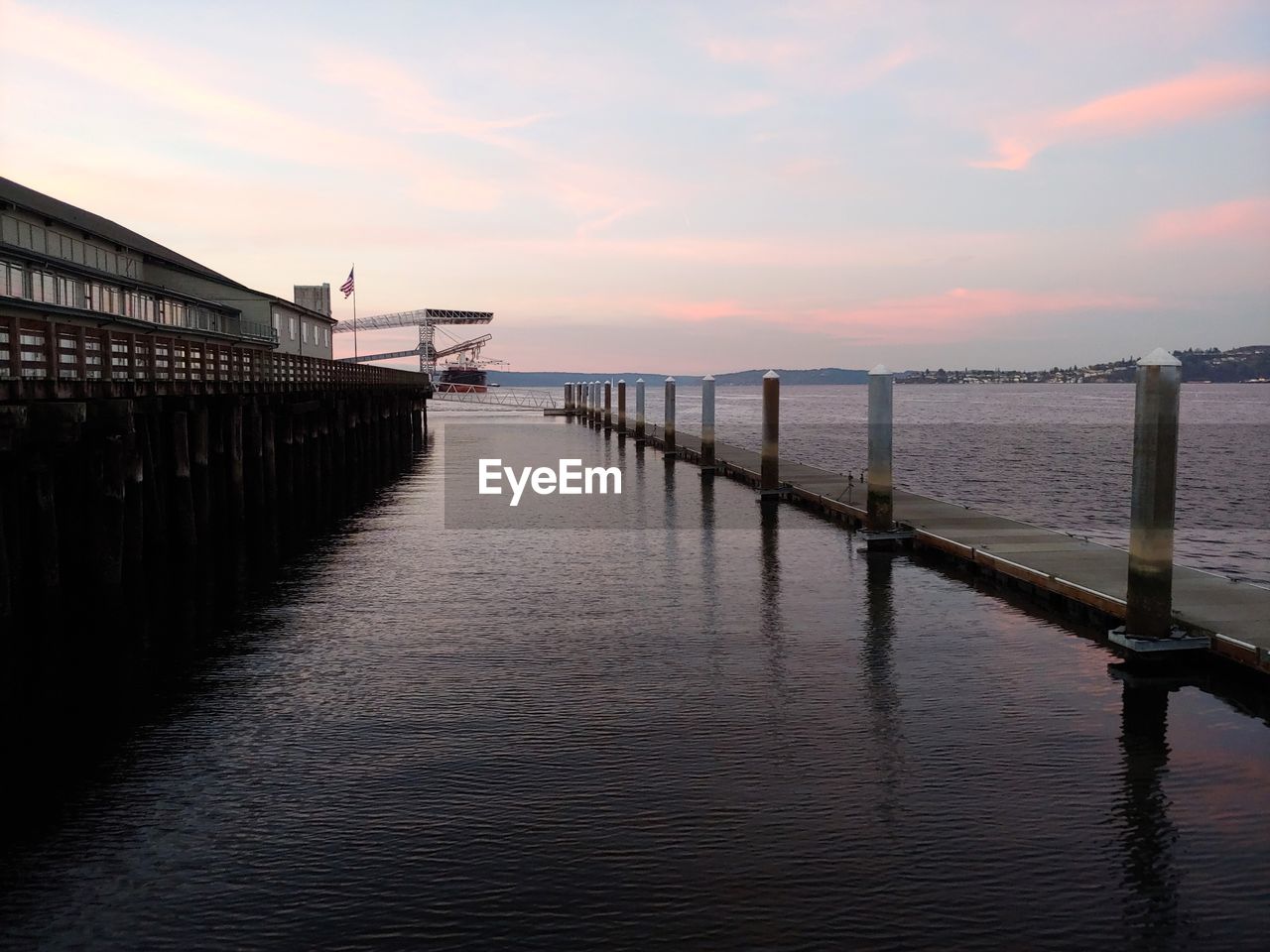 PIER AMIDST SEA AGAINST SKY DURING SUNSET