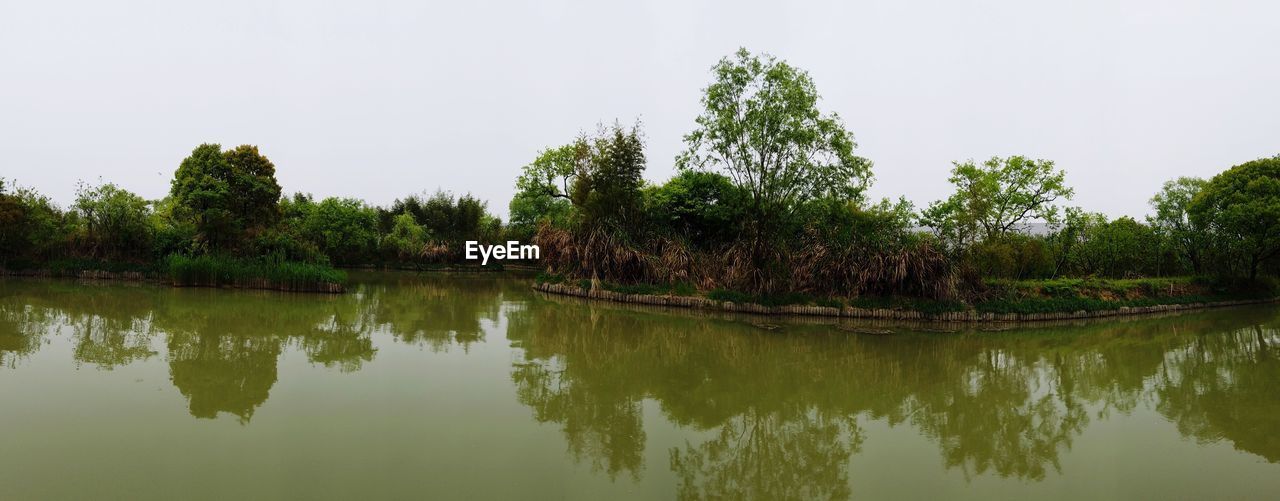 SCENIC VIEW OF CALM LAKE AGAINST SKY