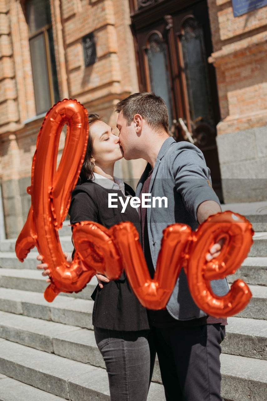 Valentines day celebration and dating concept. happy loving couple with red love balloons in the 