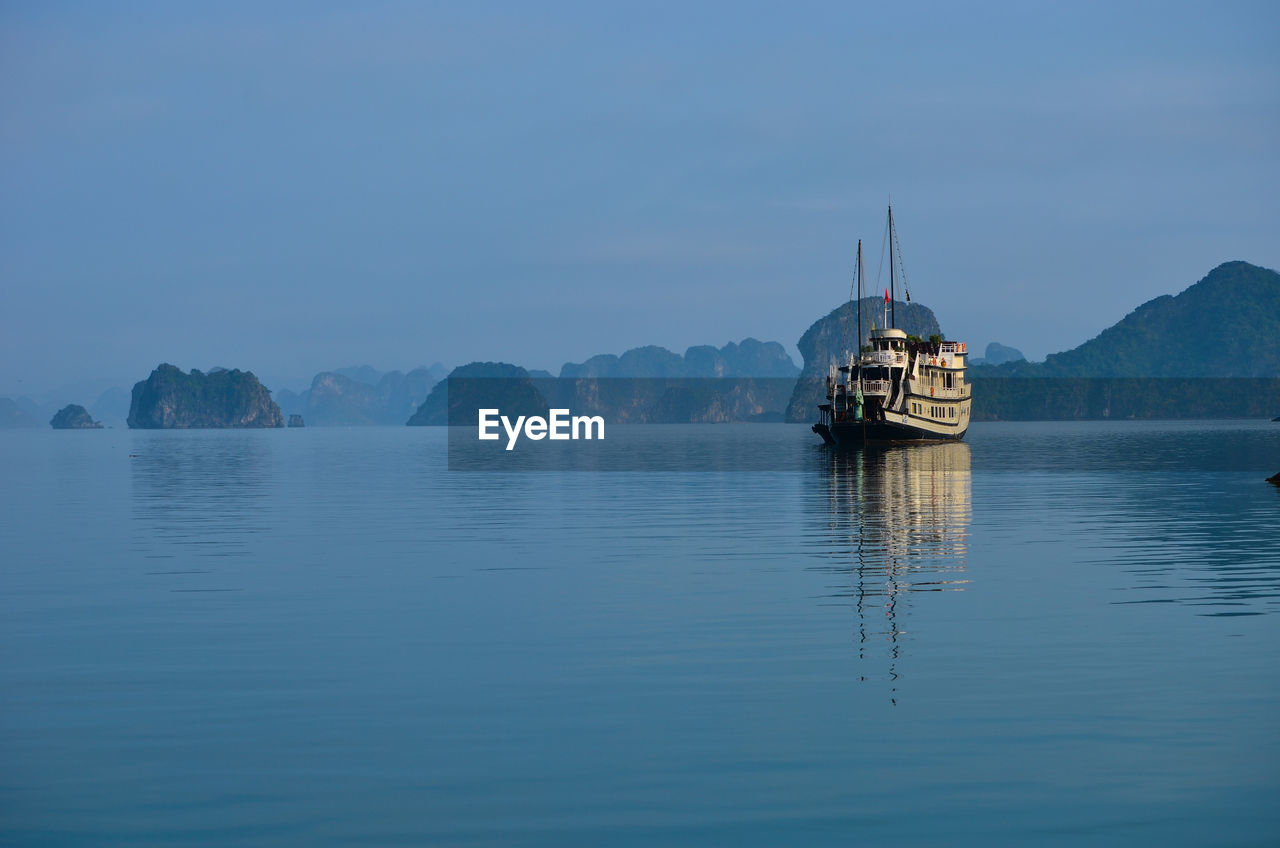 Boat sailing in river against clear sky