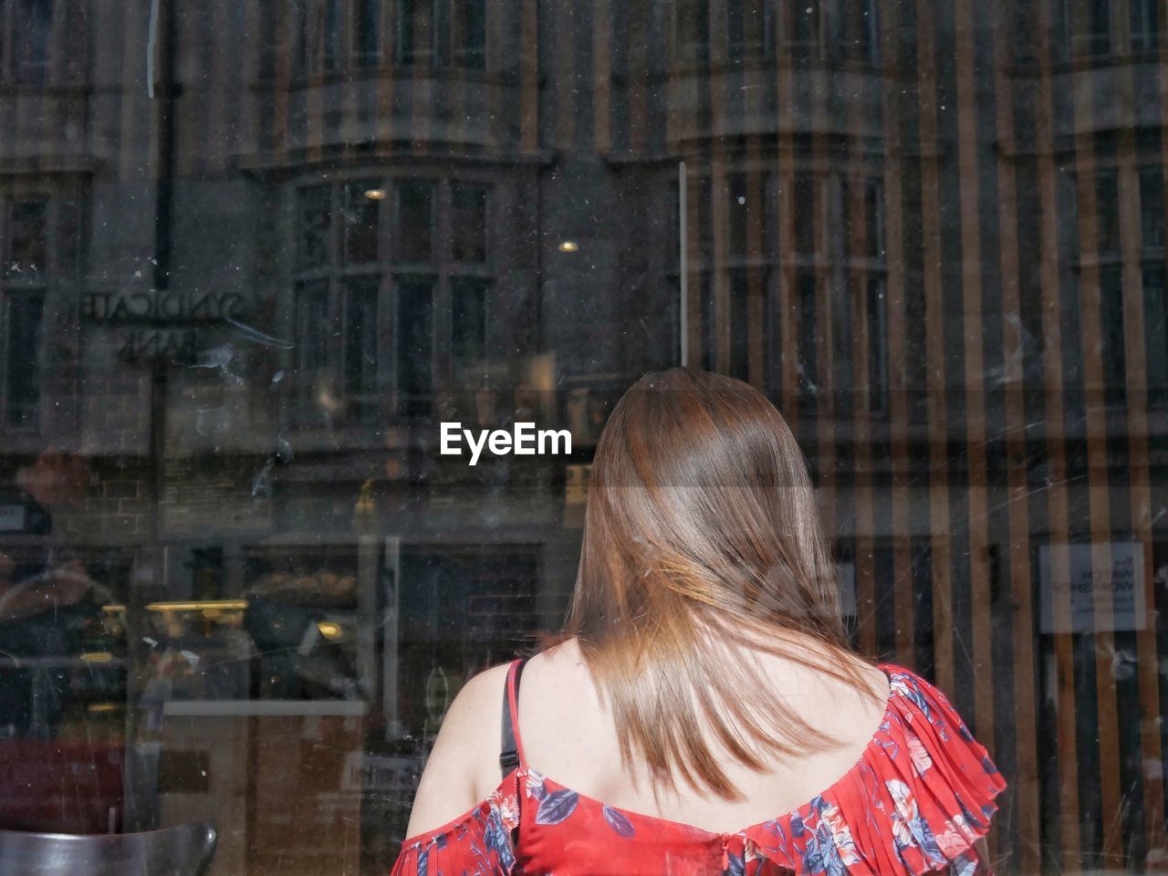 REAR VIEW OF WOMAN IN FRONT OF BUILDING