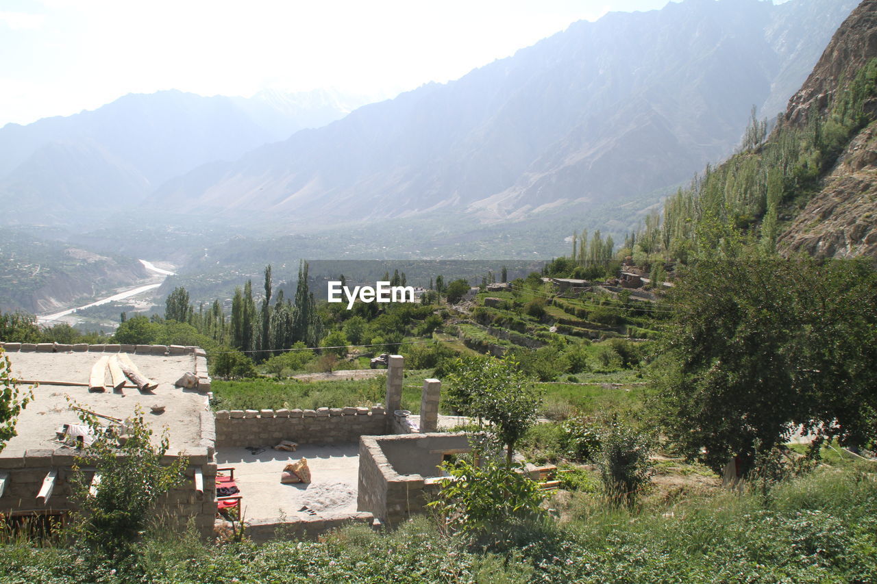 HIGH ANGLE VIEW OF TREES AND BUILDINGS ON FIELD