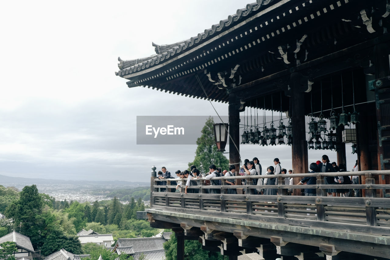 People visiting temple against sky