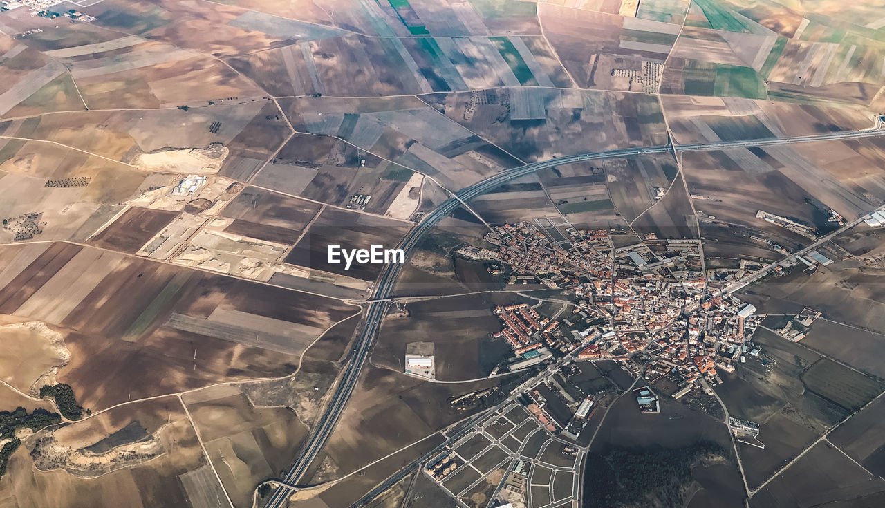 High angle view of cityscape against cultivated land 