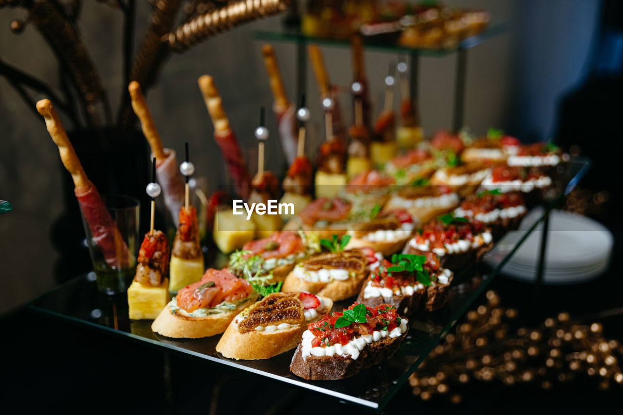 Luxury glass table with canapes on skewers. canapes with a variety of cheeses, salmon, salsa.