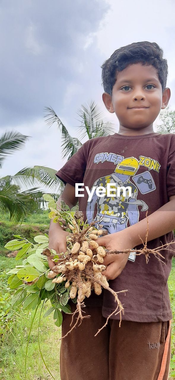 childhood, child, plant, flower, nature, spring, women, female, portrait, smiling, emotion, happiness, day, men, leisure activity, outdoors, lifestyles, casual clothing, one person, sky, cute, adult, holding, person, looking, innocence, tree, growth, baby, positive emotion, looking at camera