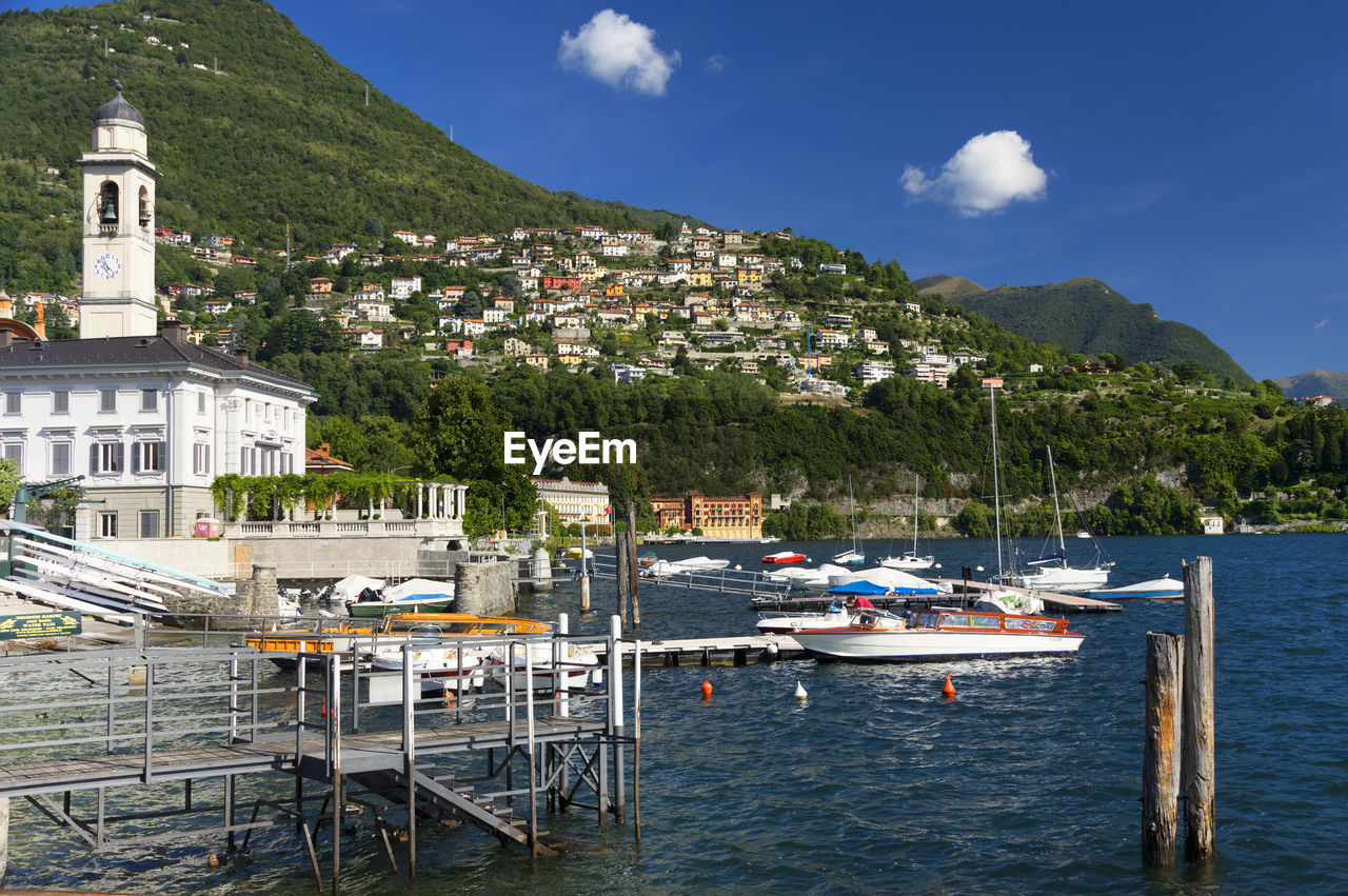 Boats moored in lake against landscape