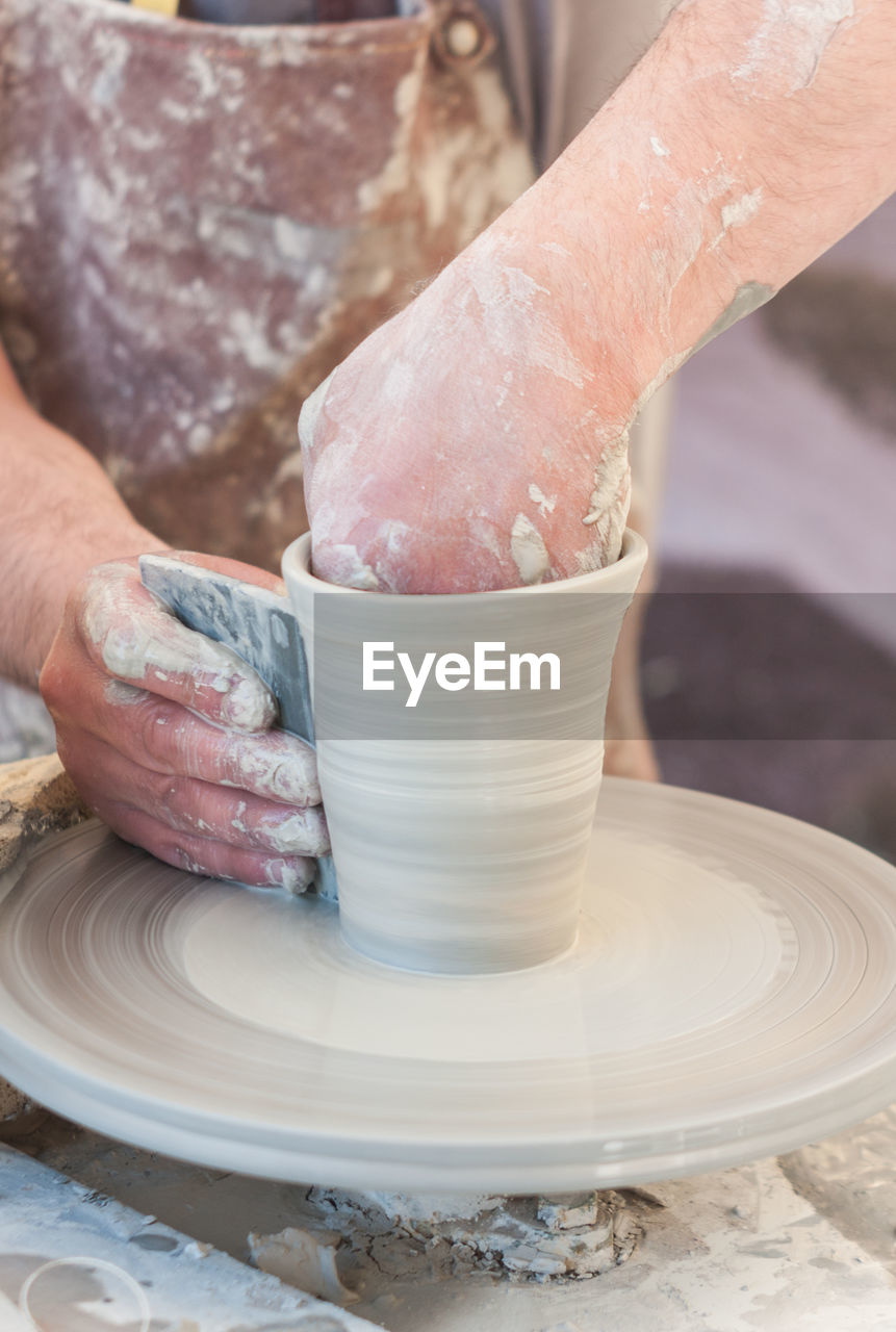 Midsection of man making pottery