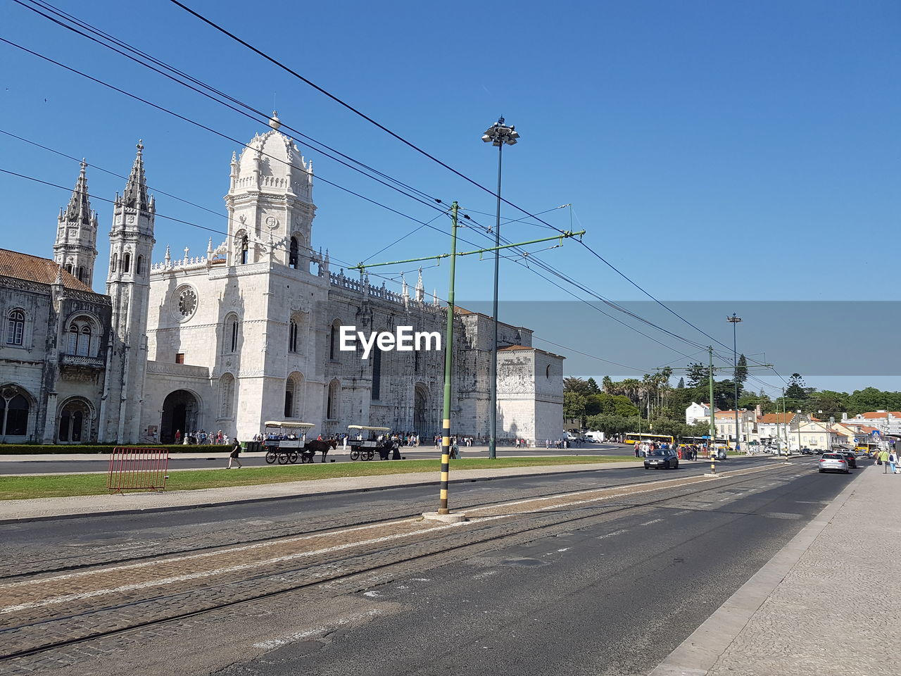 Road by buildings against clear sky