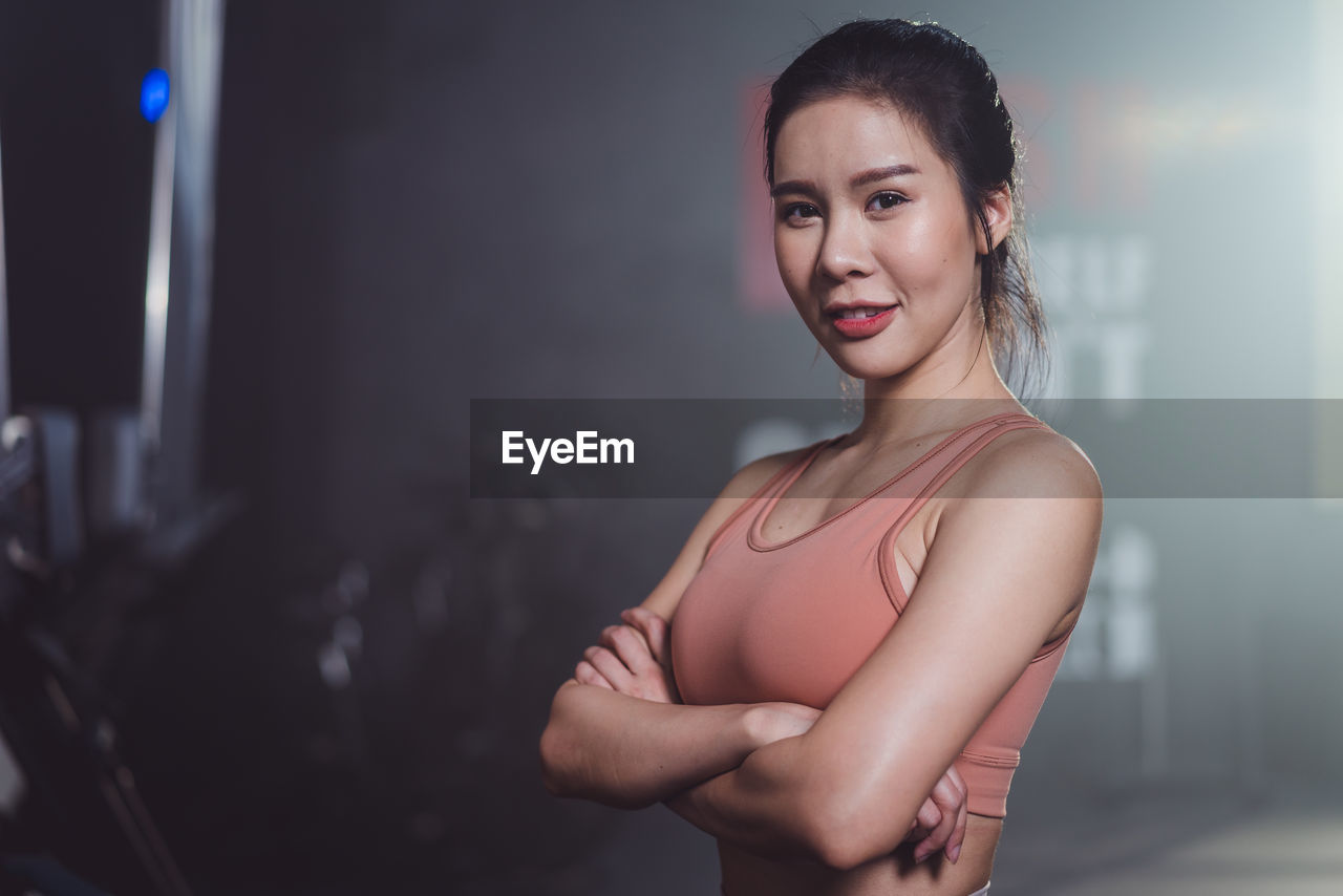 portrait of young woman looking away in gym