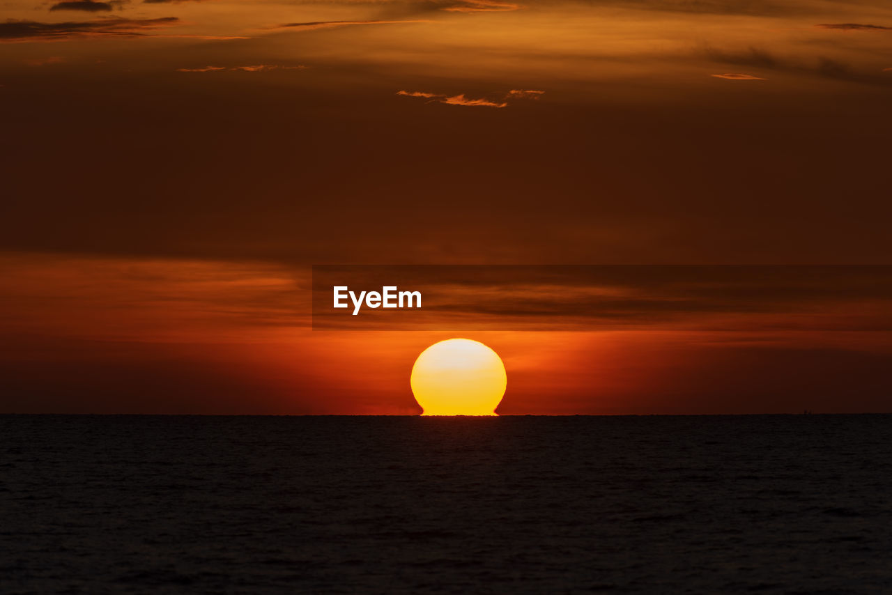 SCENIC VIEW OF SEA AGAINST ORANGE SKY DURING SUNSET