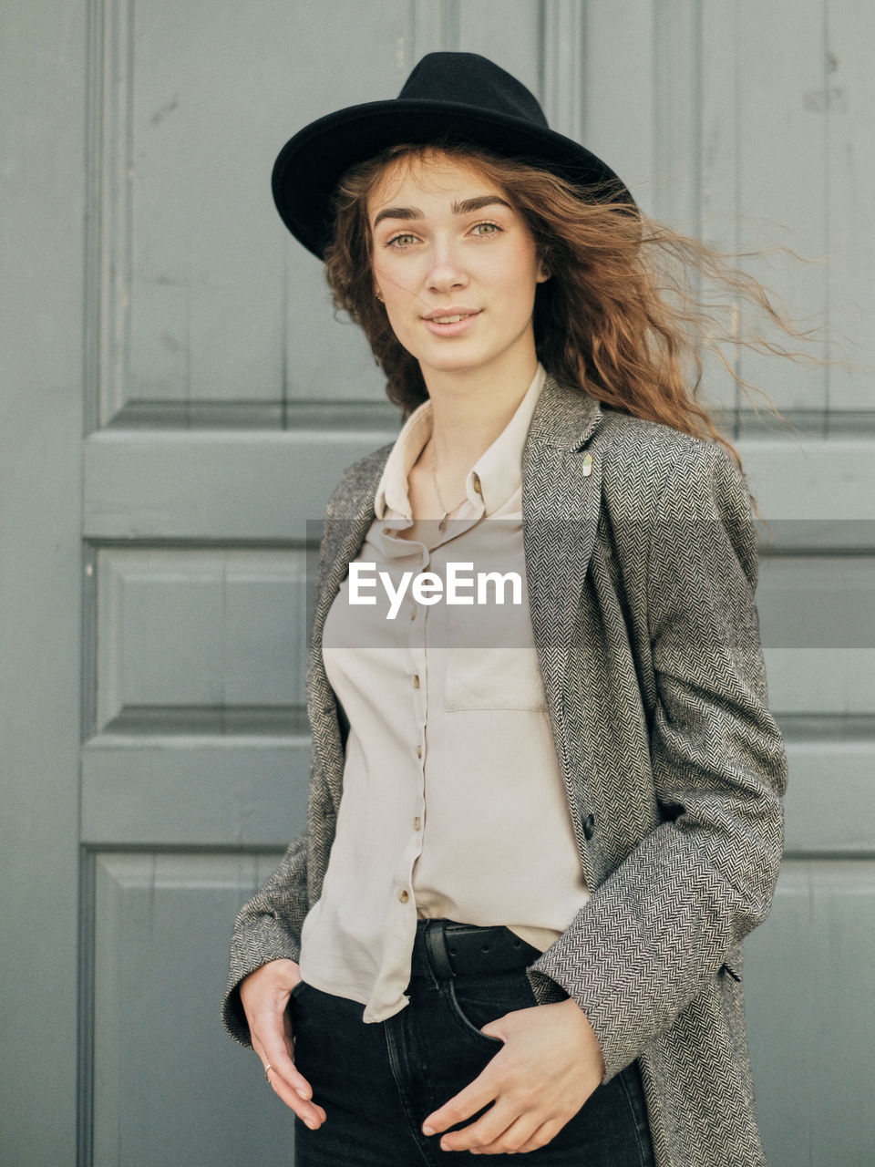 Portrait of woman standing against wall