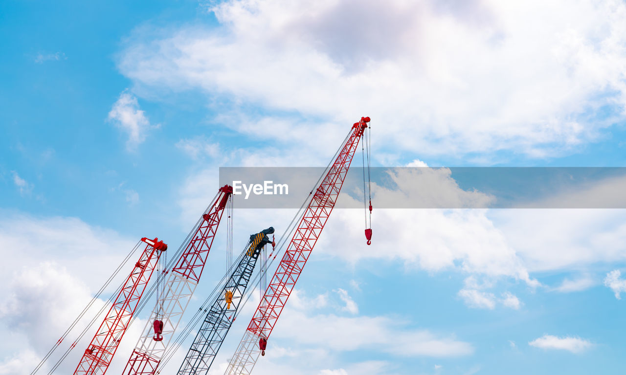 Crawler crane against blue sky and white clouds. real estate industry. red crawler crane.