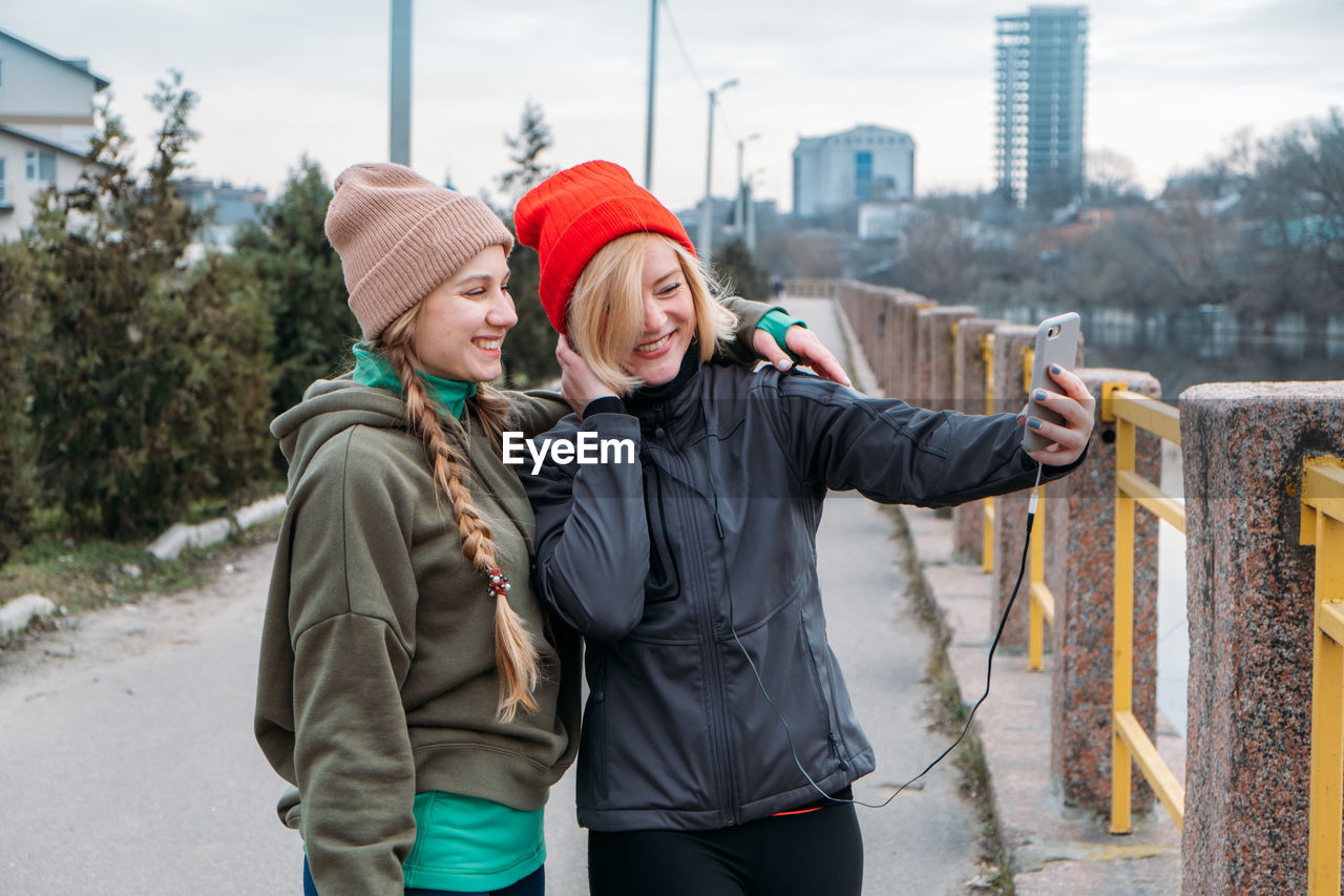 Women talking selfie while standing outdoors