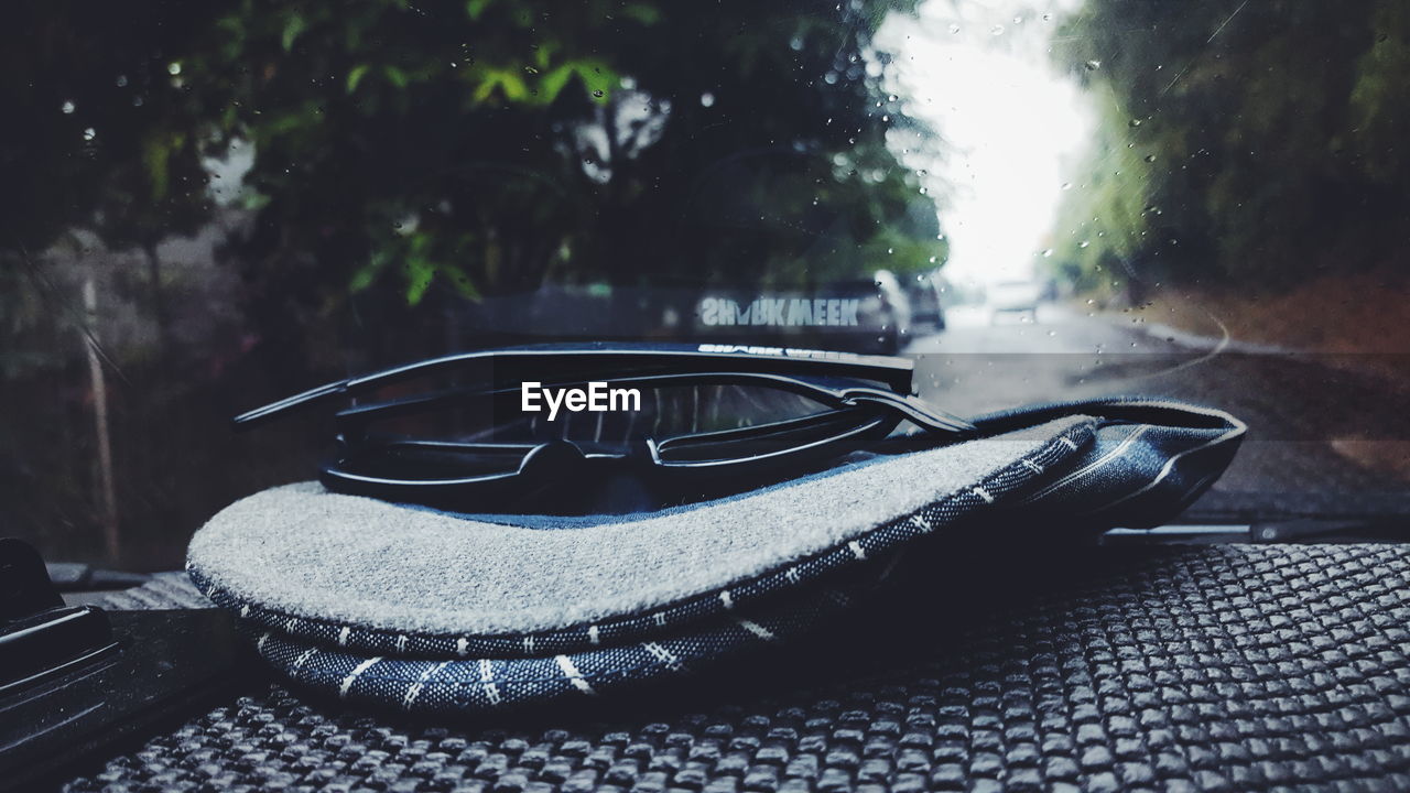 Close-up of cap and sunglasses on dashboard in car