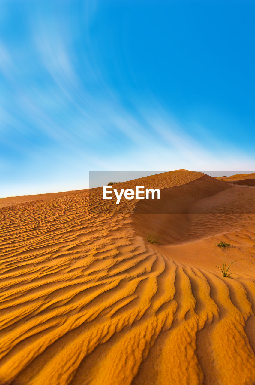 Sand dunes in desert against sky