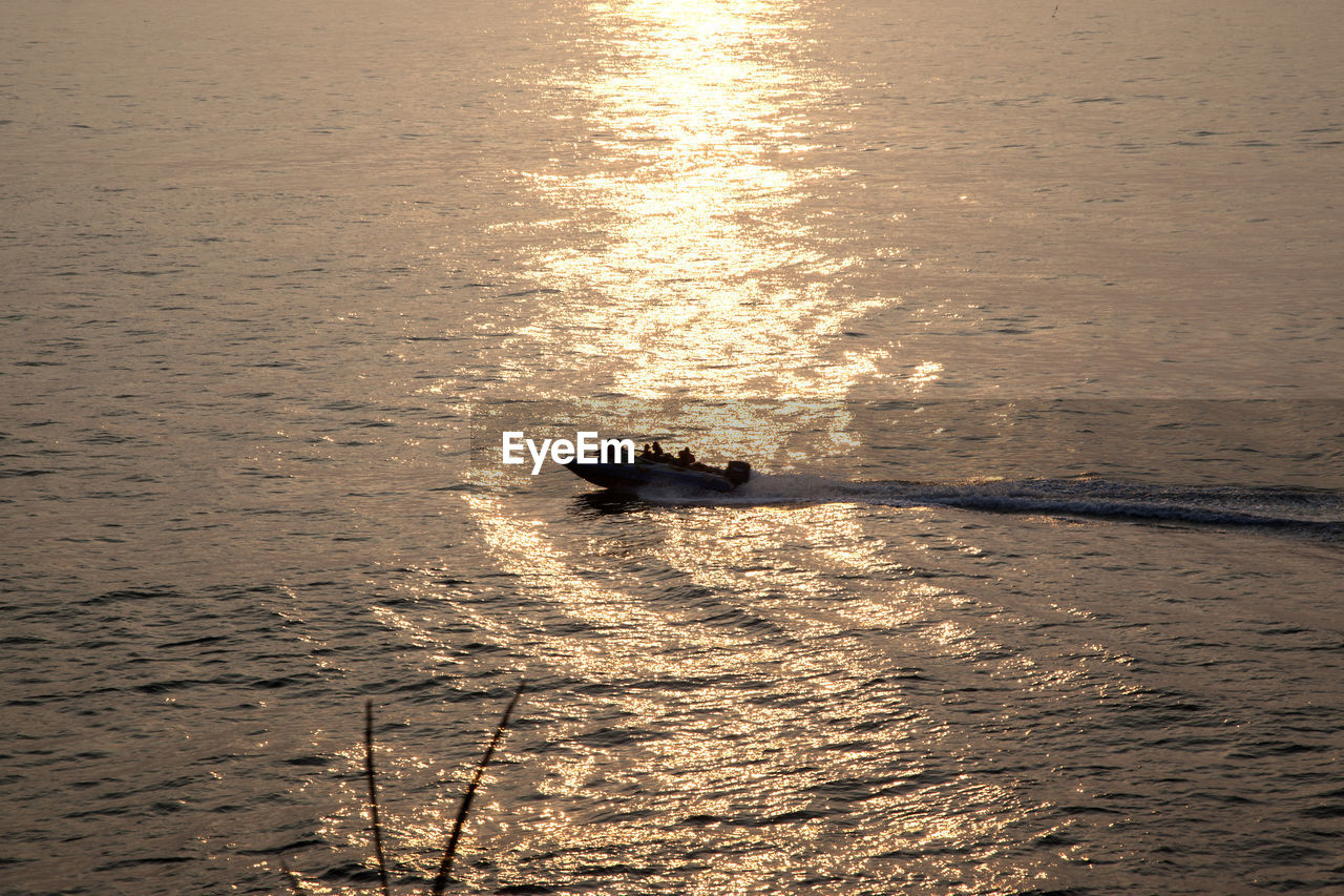 High angle view of silhouette jet boat on sea during sunset