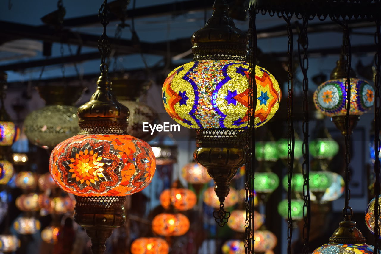 Illuminated lanterns hanging at market stall