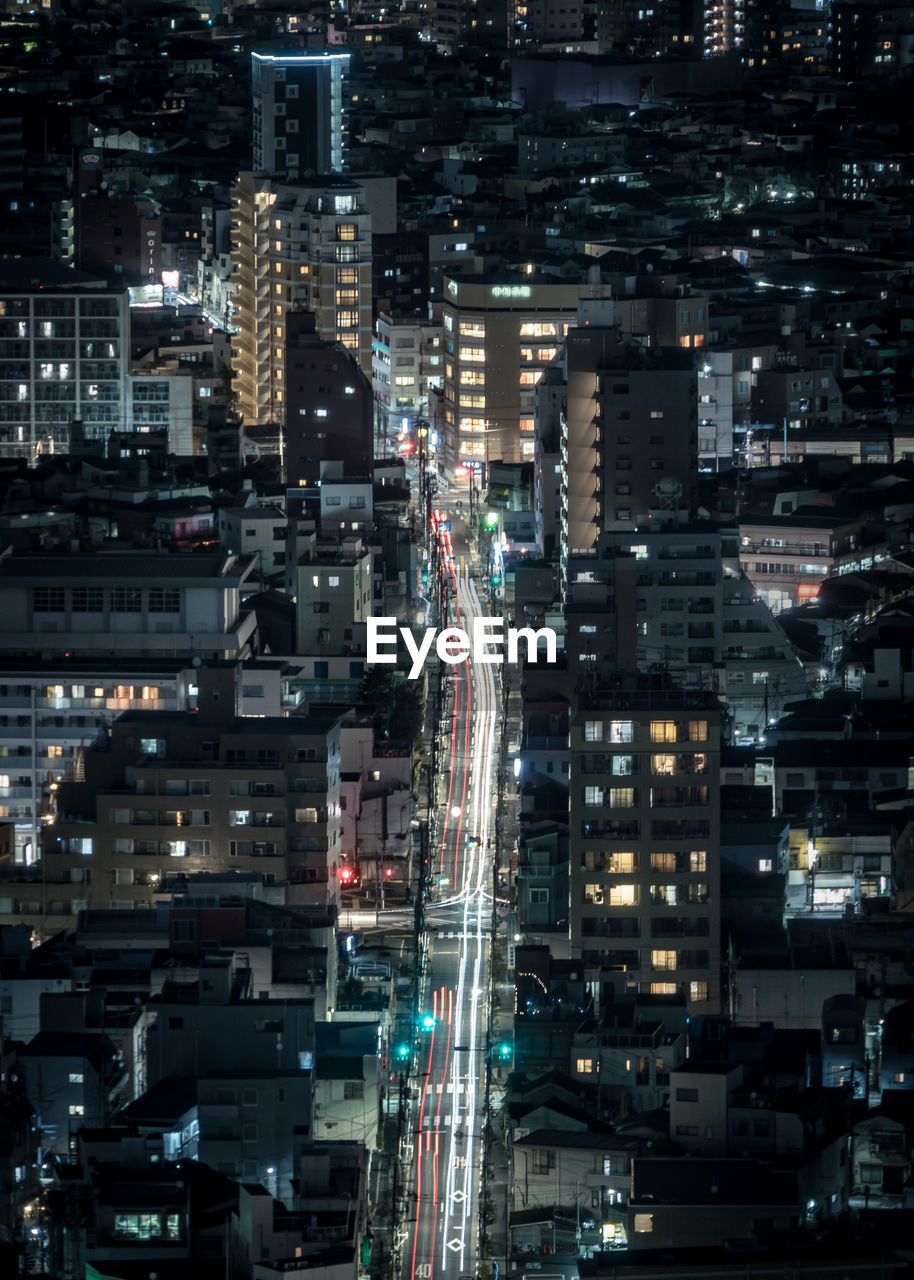 Aerial view of illuminated buildings and road in city at night