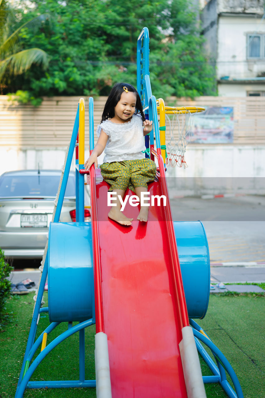 Full length of girl on slide at playground