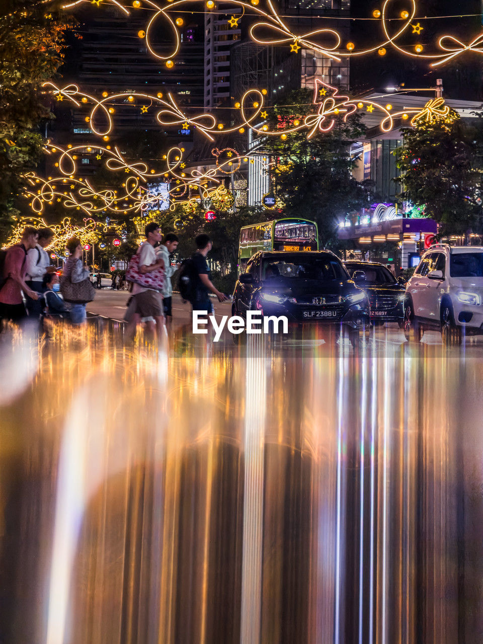 night, reflection, illuminated, city, architecture, motion, light, evening, long exposure, water, blurred motion, built structure, building exterior, cityscape, travel destinations, city life, transportation, celebration, street, outdoors, nature, crowd, group of people, travel, mode of transportation, lighting equipment, tree