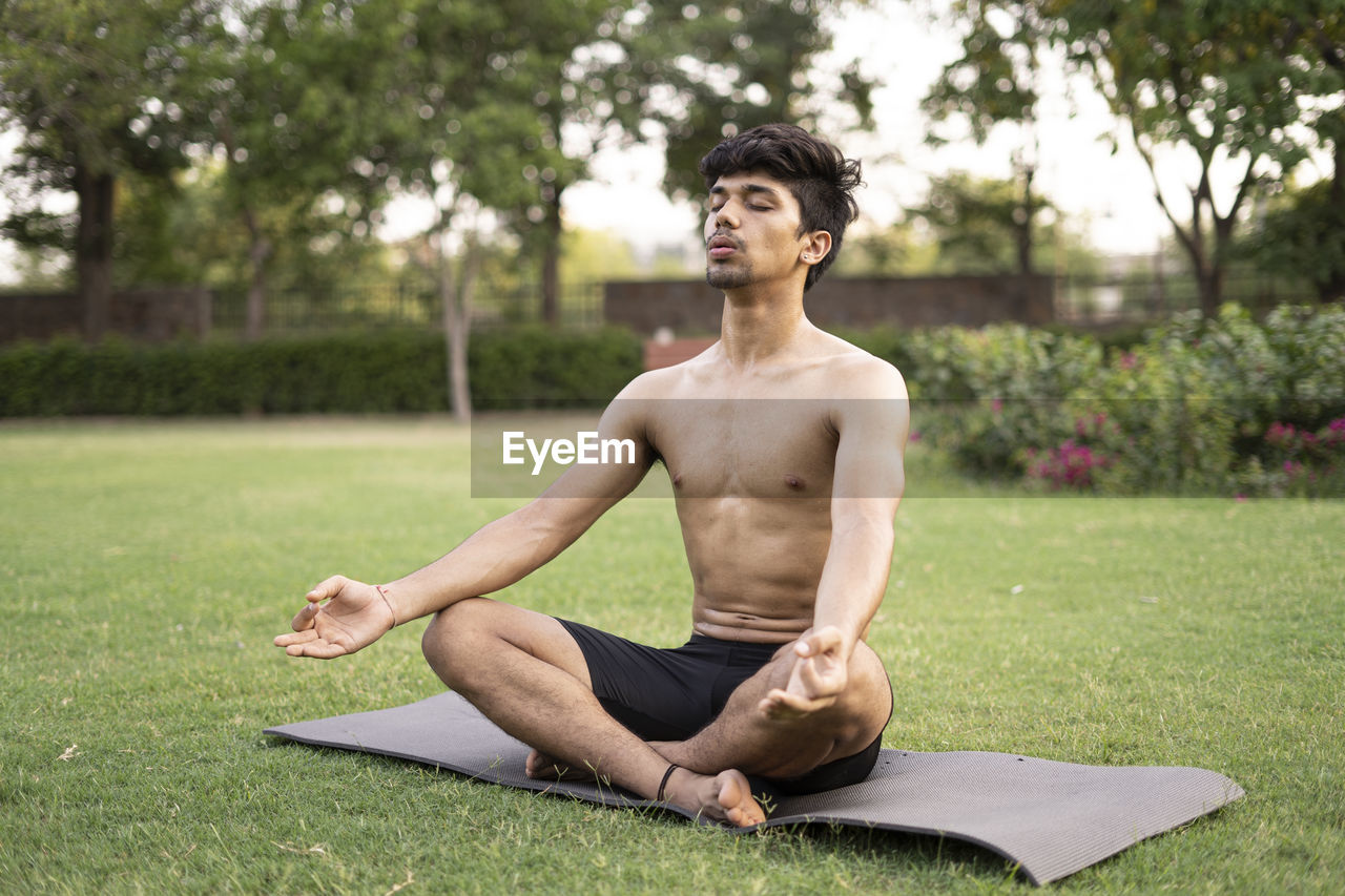 MAN SITTING ON GRASS