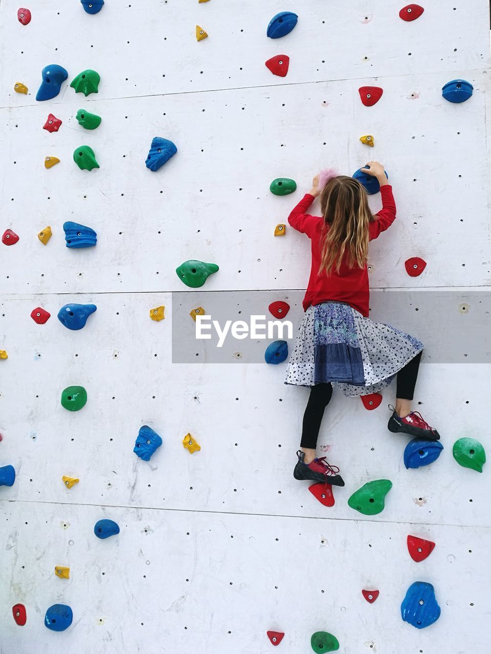 Rear view of girl on climbing wall