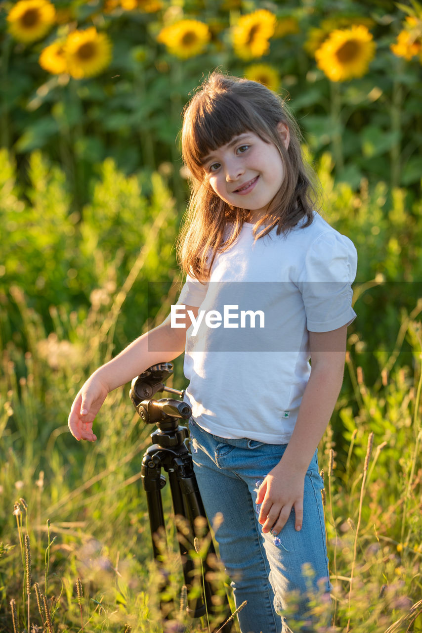 Portrait of girl standing in sunflower field