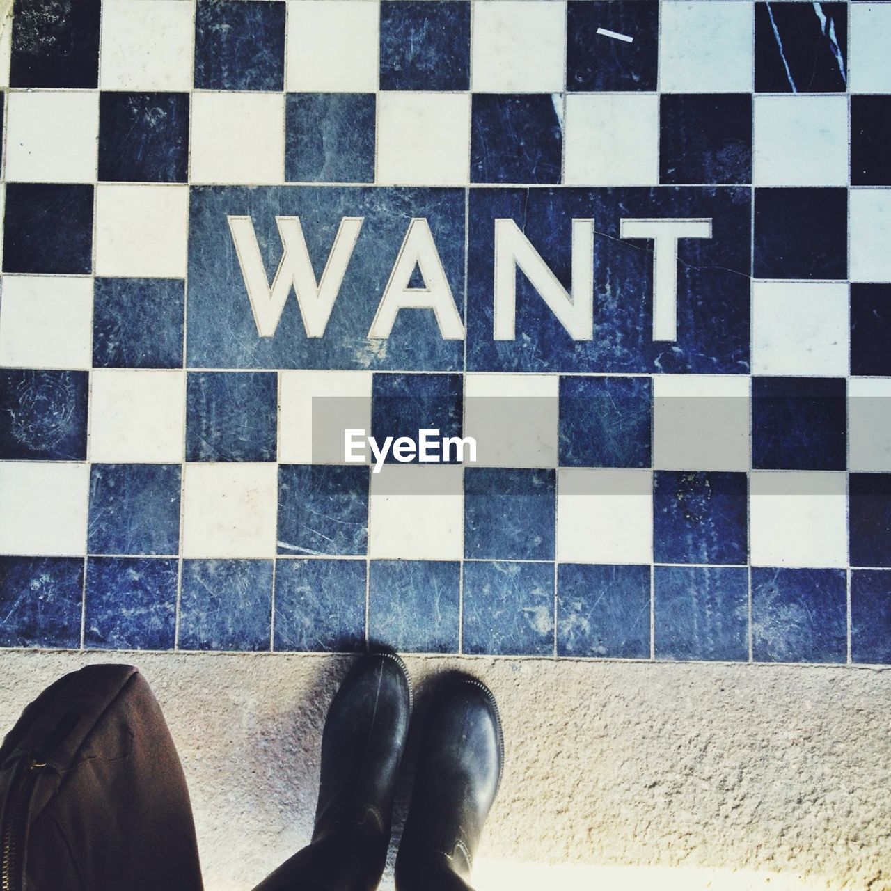 Low section of person standing by chequered floor