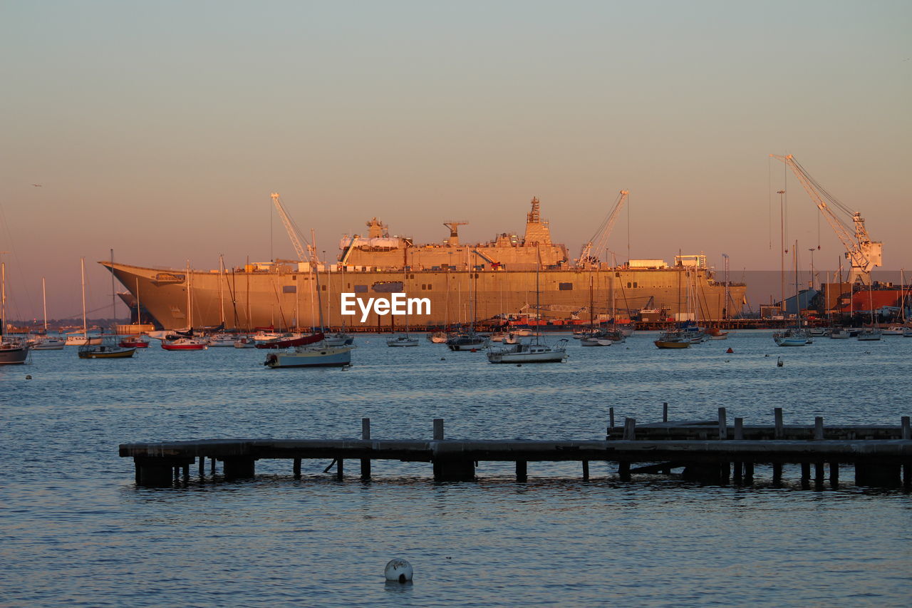 Silhouette of boats at harbor during sunset